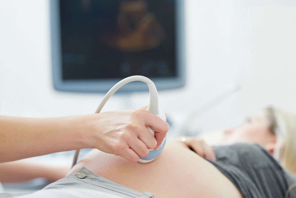 A pregnant woman in a doctor's office receiving an ultrasound.